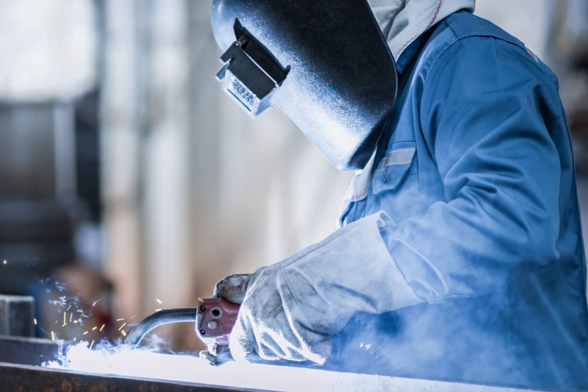 Industrial welder welding fabricated construction in factory, Welding process by Flux Core Welding, FCAW