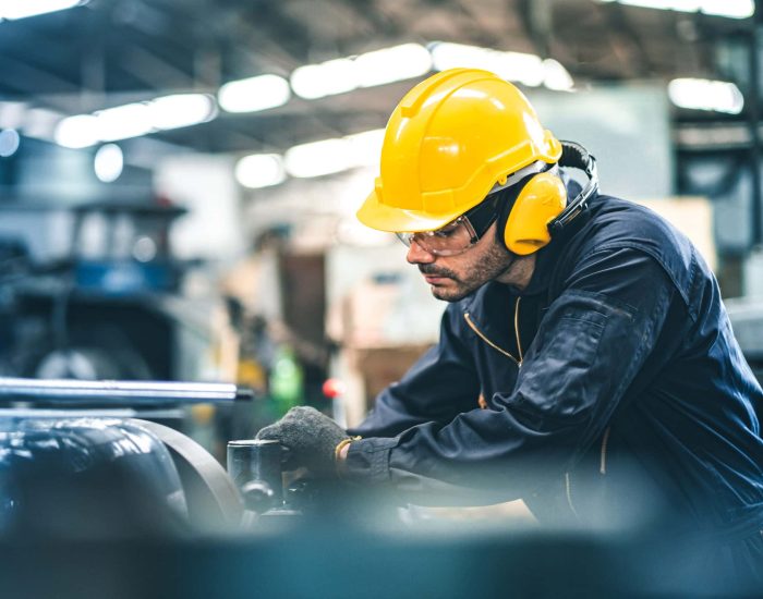Industrial Engineers in Hard Hats.Work at the Heavy Industry Manufacturing Factory.industrial worker indoors in factory. man working in an industrial factory.Safety first concept.