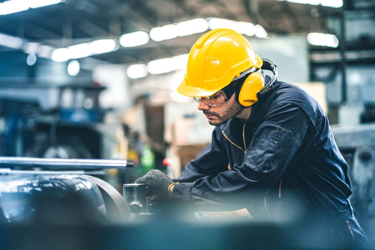 Industrial Engineers in Hard Hats.Work at the Heavy Industry Manufacturing Factory.industrial worker indoors in factory. man working in an industrial factory.Safety first concept.
